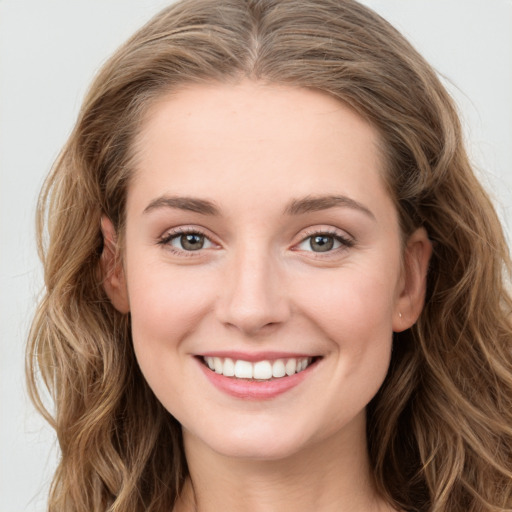 Joyful white young-adult female with long  brown hair and green eyes