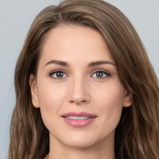 Joyful white young-adult female with long  brown hair and green eyes