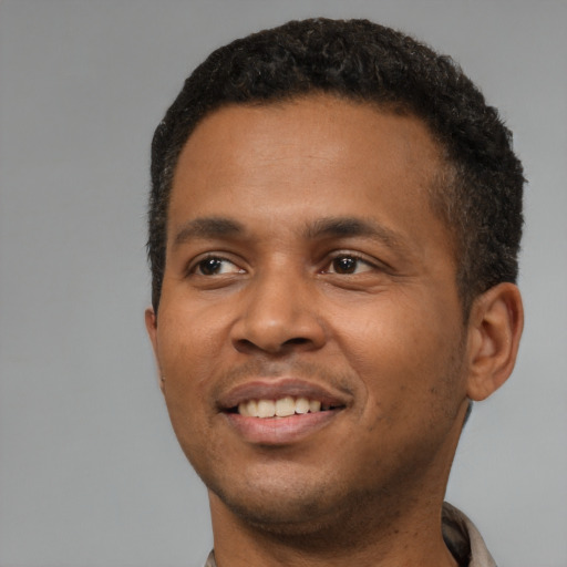 Joyful black young-adult male with short  black hair and brown eyes