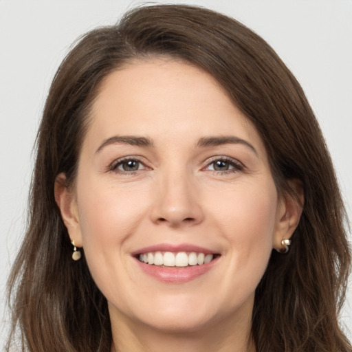 Joyful white young-adult female with long  brown hair and brown eyes