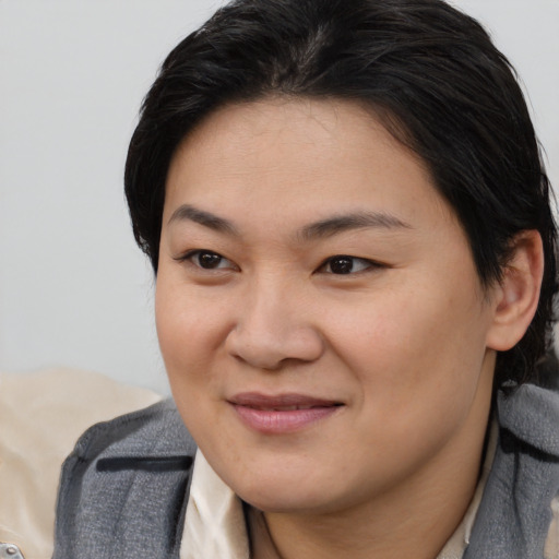 Joyful asian young-adult female with short  brown hair and brown eyes