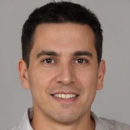 Joyful white young-adult male with short  brown hair and brown eyes