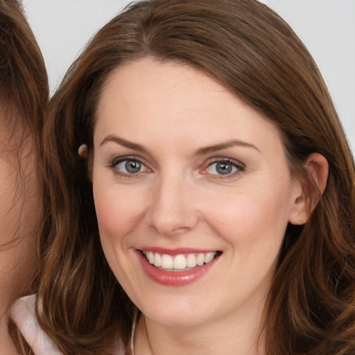 Joyful white young-adult female with long  brown hair and brown eyes