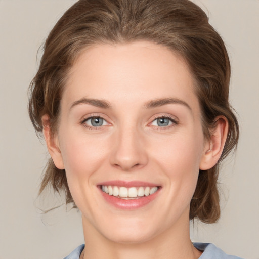 Joyful white young-adult female with medium  brown hair and grey eyes