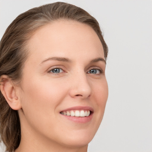 Joyful white young-adult female with long  brown hair and grey eyes