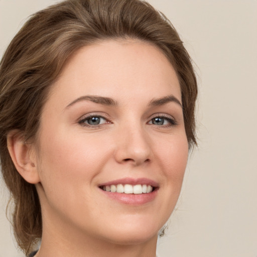 Joyful white young-adult female with medium  brown hair and green eyes