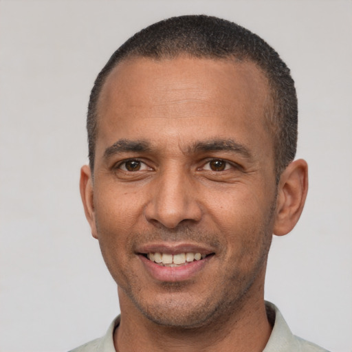 Joyful latino adult male with short  black hair and brown eyes