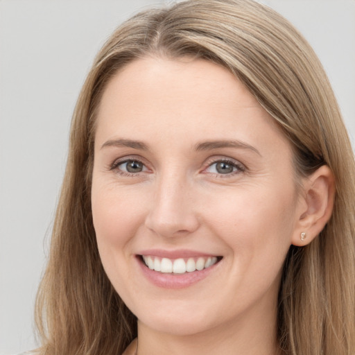 Joyful white young-adult female with long  brown hair and grey eyes