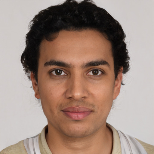 Joyful latino young-adult male with short  black hair and brown eyes