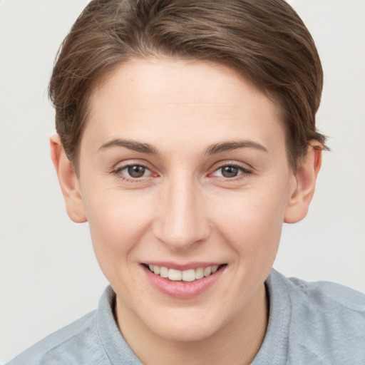 Joyful white young-adult female with short  brown hair and grey eyes