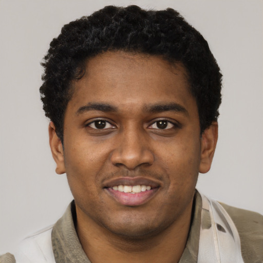 Joyful black young-adult male with short  black hair and brown eyes