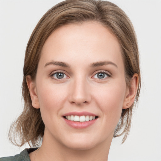 Joyful white young-adult female with medium  brown hair and grey eyes