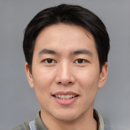 Joyful asian young-adult male with short  brown hair and brown eyes