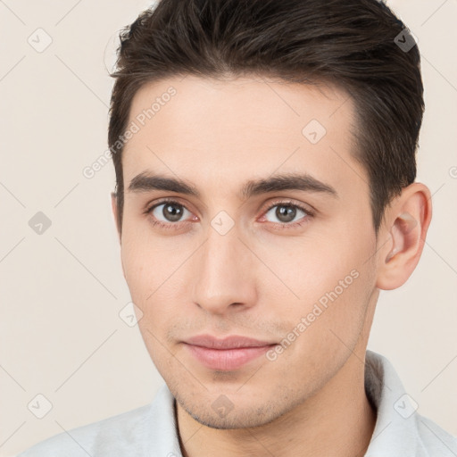 Joyful white young-adult male with short  brown hair and brown eyes