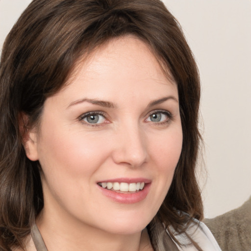 Joyful white young-adult female with medium  brown hair and grey eyes