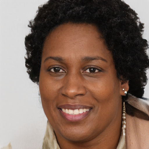 Joyful black adult female with long  brown hair and brown eyes