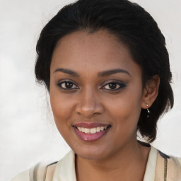 Joyful black young-adult female with long  brown hair and brown eyes