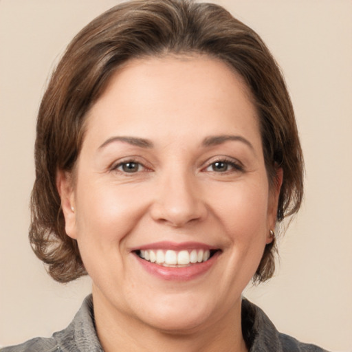 Joyful white adult female with medium  brown hair and grey eyes