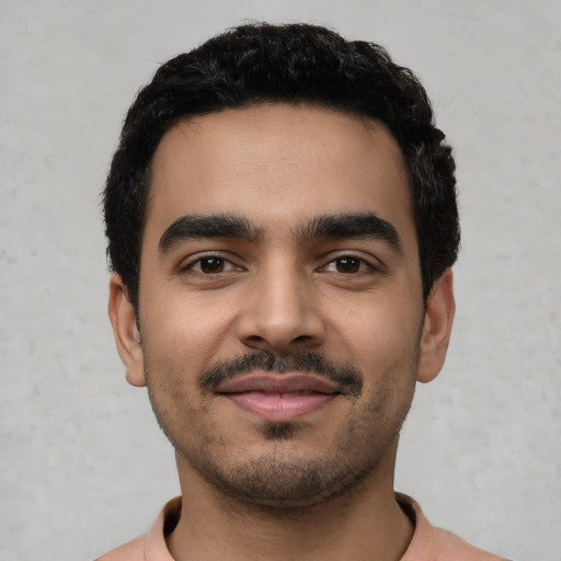Joyful latino young-adult male with short  black hair and brown eyes