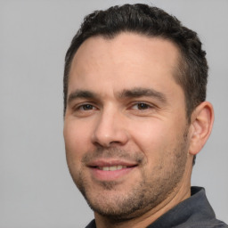 Joyful white young-adult male with short  black hair and brown eyes