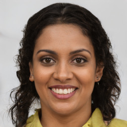 Joyful black young-adult female with long  brown hair and brown eyes