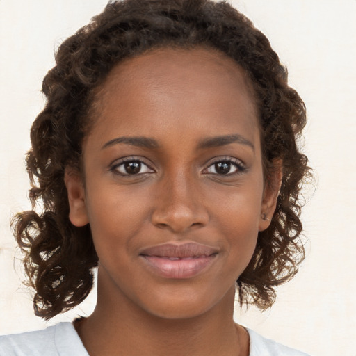 Joyful black young-adult female with medium  brown hair and brown eyes