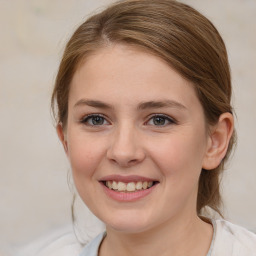 Joyful white young-adult female with medium  brown hair and blue eyes