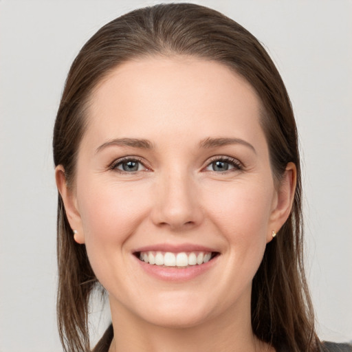 Joyful white young-adult female with long  brown hair and grey eyes