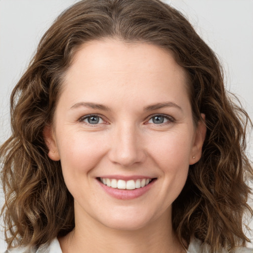 Joyful white young-adult female with long  brown hair and grey eyes