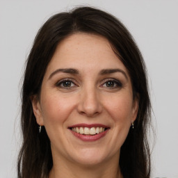 Joyful white adult female with long  brown hair and grey eyes