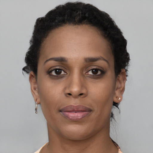 Joyful black young-adult female with short  brown hair and brown eyes