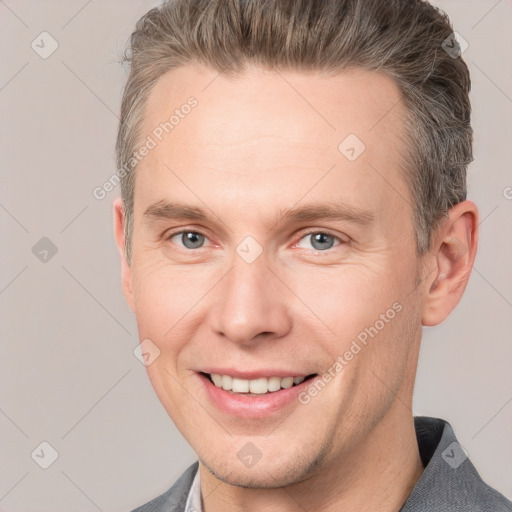 Joyful white adult male with short  brown hair and grey eyes