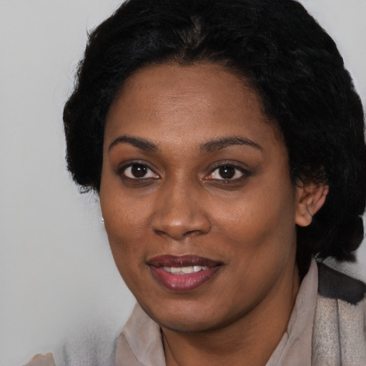 Joyful black young-adult female with short  black hair and brown eyes