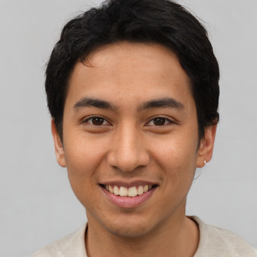 Joyful asian young-adult male with short  brown hair and brown eyes