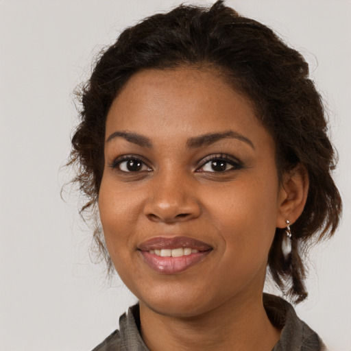 Joyful black young-adult female with long  brown hair and brown eyes