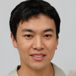 Joyful asian young-adult male with short  brown hair and brown eyes