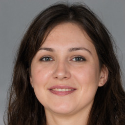 Joyful white young-adult female with long  brown hair and grey eyes