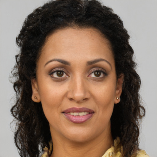 Joyful black adult female with long  brown hair and brown eyes