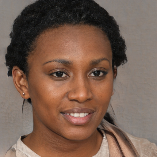 Joyful black young-adult female with short  brown hair and brown eyes