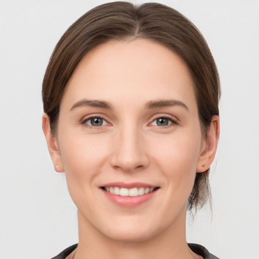 Joyful white young-adult female with medium  brown hair and grey eyes