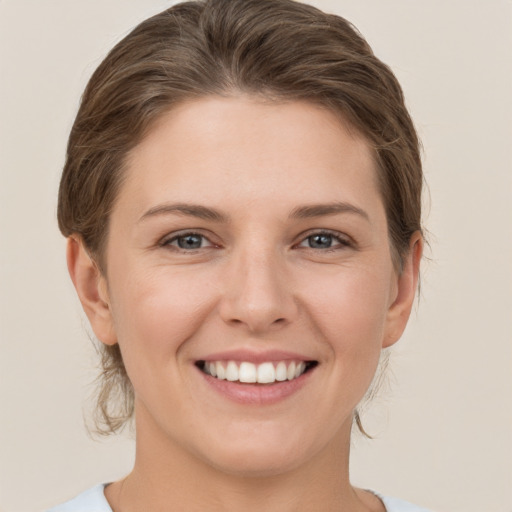 Joyful white young-adult female with medium  brown hair and grey eyes