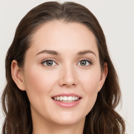 Joyful white young-adult female with long  brown hair and grey eyes