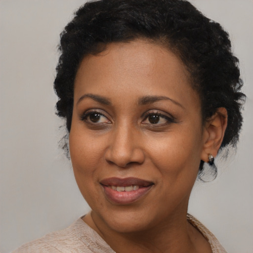 Joyful black young-adult female with short  black hair and brown eyes