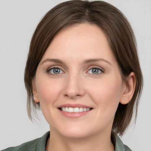 Joyful white young-adult female with medium  brown hair and grey eyes