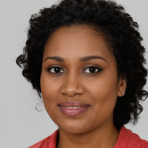 Joyful black young-adult female with long  black hair and brown eyes
