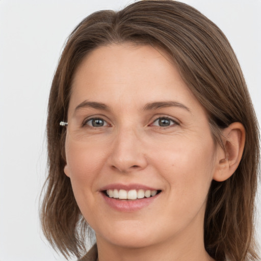 Joyful white young-adult female with medium  brown hair and grey eyes