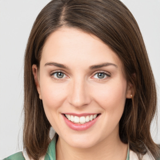 Joyful white young-adult female with medium  brown hair and green eyes