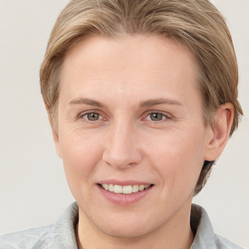 Joyful white adult female with short  brown hair and grey eyes