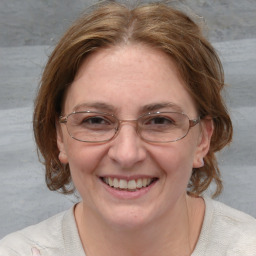 Joyful white adult female with medium  brown hair and blue eyes