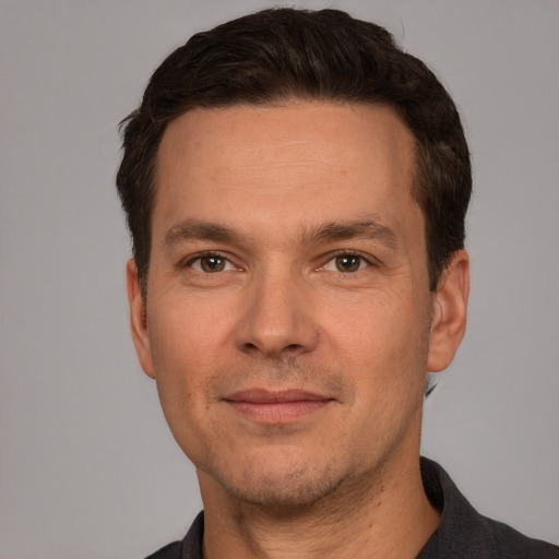 Joyful white adult male with short  brown hair and brown eyes